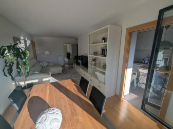 Mesa de comedor en el salón que aprovecha la luz que entra por la terraza