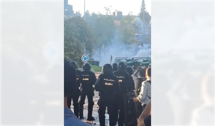 Varios encapuchados vuelcan y queman contenedores en presencia de un cordón policial junto al tanatorio San Alberto