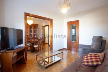 Zona de sofás y televisión con vistas del comedor al fondo