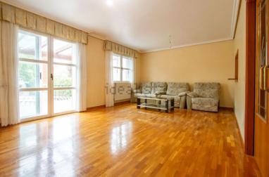 Salón con acceso y ventanales al jardín