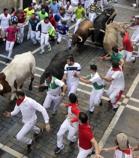 Momentos de tensión cuando el morlaco jabonero de la ganadería de Núñez del Cuvillo perdió pie en la calle Estafeta y cayó al suelo, rodeado de mozos.