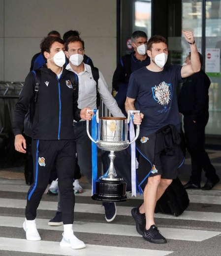 Cientos de aficionados de la Real Sociedad han aguardado en los márgenes de la carretera que conecta el aeropuerto de Hondarribia con San Sebastián para saludar a los campeones de la Copa del Rey.