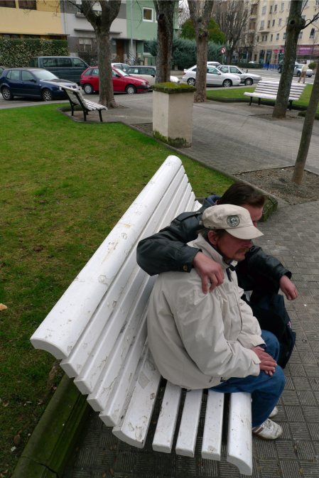 Jacek murió como vivió, en la calle, bajo este banco de madera blanco de la avenida Baja Navarra. Falleció la madrugada del 13 de noviembre de 2011. En la imagen, dos de sus amigos en abril, posan para un reportaje que publicó este periódico.