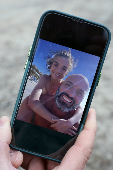 Armando camina por su hija Gioia, de nueve años, en la pantalla del móvil.