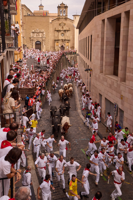 Fotos del séptimo encierro de San Fermín 2026 con toros de Miura en la cuesta de Santo Domingo.