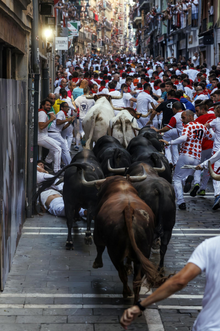 Fotos del octavo encierro de San Fermín 2026 con toros de la ganadería de Jandilla en la curva de Mercaderes.