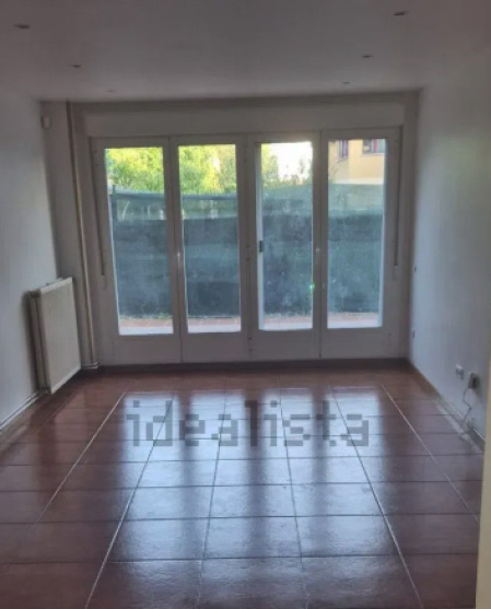 Salón con una amplia cristalera al jardín