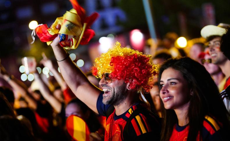 Aficionados celebran la victoria de España en las semifinales del Mundial 2026 que han disputado frente a Francia, desde la "fan zone" de la Plaza de Colón en Madrid, este martes