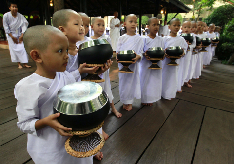 Monjas y novicias budistas rezando y pidiendo comida en Bangkok