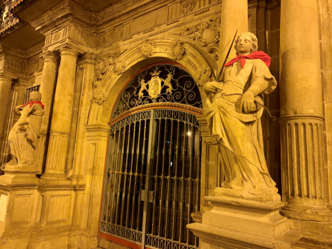 Fotos de las esculturas de Pamplona adornadas con pañuelicos rojos.