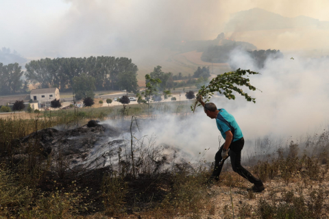 Fotos del incendio producido entre Obanos y Legarda. Vecinos de Obanos colaboran con los bomberos en la extinción del fuego en las viviendas.