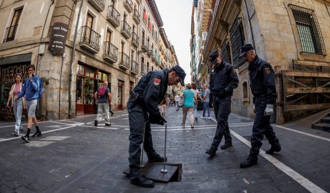 -Efectivos de la Unidad de Subsuelo de la Policía Nacional cierran la tapa de acceso de la calle Estafeta a los túneles del alcantarillado de Pamplona después de comprobar su interior.