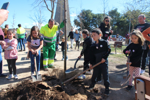 VARIOS NIÑOS PLANTAN UNO DE LOS EJEMPLARES EN EL ENTORNO DEL CORAZÓN DE MARÍA DE TUDELA