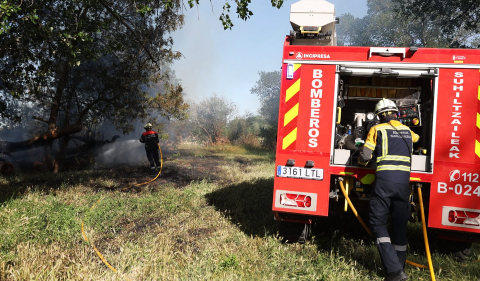 Bomberos de Navarra y agentes de la Policía Municipal de Tudela trabajan en la extinción del fuego declarado en la desembocadura del río Mediavilla