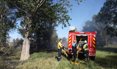 Bomberos de Navarra y agentes de la Policía Municipal de Tudela trabajan en la extinción del fuego declarado en la desembocadura del río Mediavilla