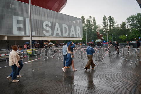 Los seguidores del cantante se refugiaron de la lluvia a la entrada del pabellón Navarra Arena