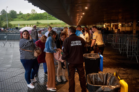 Los seguidores del cantante se refugiaron de la lluvia a la entrada del pabellón Navarra Arena