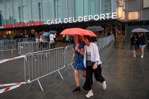 Los seguidores del cantante se refugiaron de la lluvia a la entrada del pabellón Navarra Arena