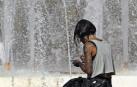 mujer y calor Una mujer trata de refrescarse de las altísimas temperaturas registradas acercándose a los chorros de una fuente urbana. EFE/Morel
