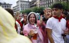 Dos jóvenes, bebida en mano, en la plaza del Castillo tras el Chupinazo