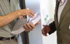 Dos profesores reparten los exámenes en el primer día de la EvAU en el campus de Tudela