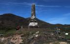 Unos turistas descansan en los bajos del monolito del castillo de Amaiur en abril de 2021