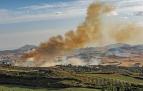 Una columna de humo, ayer por la tarde en Muzqui, con el embalse de Alloz detrás