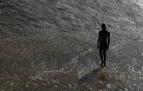 Un joven se refresca en el río Arga de Pamplona, en la zona de la pasarela de la Magdalena