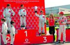 Mikel Azcona levanta la copa y recibe los aplausos de Fernando Alonso, a su derecha.