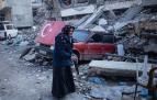 Una anciana camina entre los escombros de un edificio derribado por el terremoto en la localidad turca de Hatay.