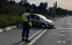 Un agente de la Guardia Civil junto al vehículo que se salió de la carretera.