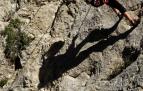 Una escaladora, toma un respiro tras completar una vía de escalada en roca