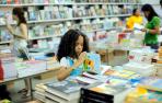 Una ni&ntilde;a ojea un libro en una librer&iacute;a en Santo Domingo.