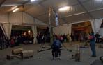El público, al fondo, contempla una exhibición de deporte rural.