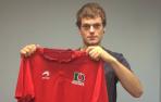 Unai Laso posa con la camiseta de Asegarce después de firmar su contrato con la empresa.