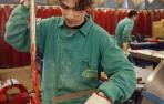 Un joven realiza un trabajo en una fábrica.