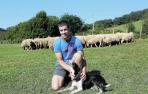 Julen Arburua Jiménez, con uno de sus perros, y parte de su rebaño, en Lekaroz.
