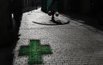 Imagen del reflejo de la cruz de una farmacia.