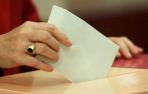 Una votante introduce su voto en la urna.