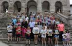 Los visitantes a la presentación de Conocer Navarra y los interventores posan con la revista frente a la iglesia de Ziga.