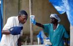 Foto de dos trabajadores sanitarios toman las medidas necesarias ante la epidemia de ébola detectada en el país.