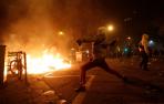 Un manifestante corre frente al fuego durante los disturbios en la Plaza de Urquinaona, en Barcelona a 18 de octubre de 2019.