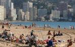 Turistas disfrutando del sol en la playa de Benidorm.