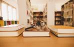 Imagen de una lupa y unas gafas sobre unos libros en la biblioteca