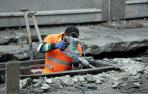 Un trabajador realiza obras en el asfalto de una calle.