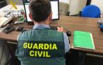 Un Guardia Civil investiga delitos informáticos en un ordenador.