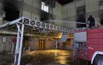 Un bombero apaga el fuego tras el atentado en el hospital en Bagdad.