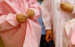 Varios niños con sus batas en un colegio.