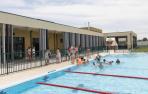 Niños del colegio de Cortes se bañan en la piscina recientemente reformada, junto al nuevo edificio del bar y los vestuarios.
