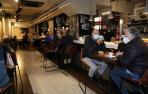 Mesas y sillas altas en el bar Río de Pamplona, como alternativa a la imposibilidad de consumir de pie en la barra
